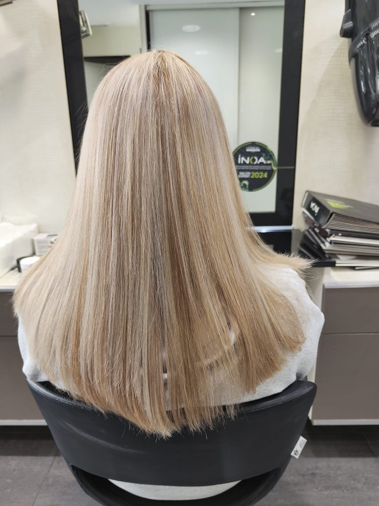 Femme de dos avec des cheveux mèchés blond cendré